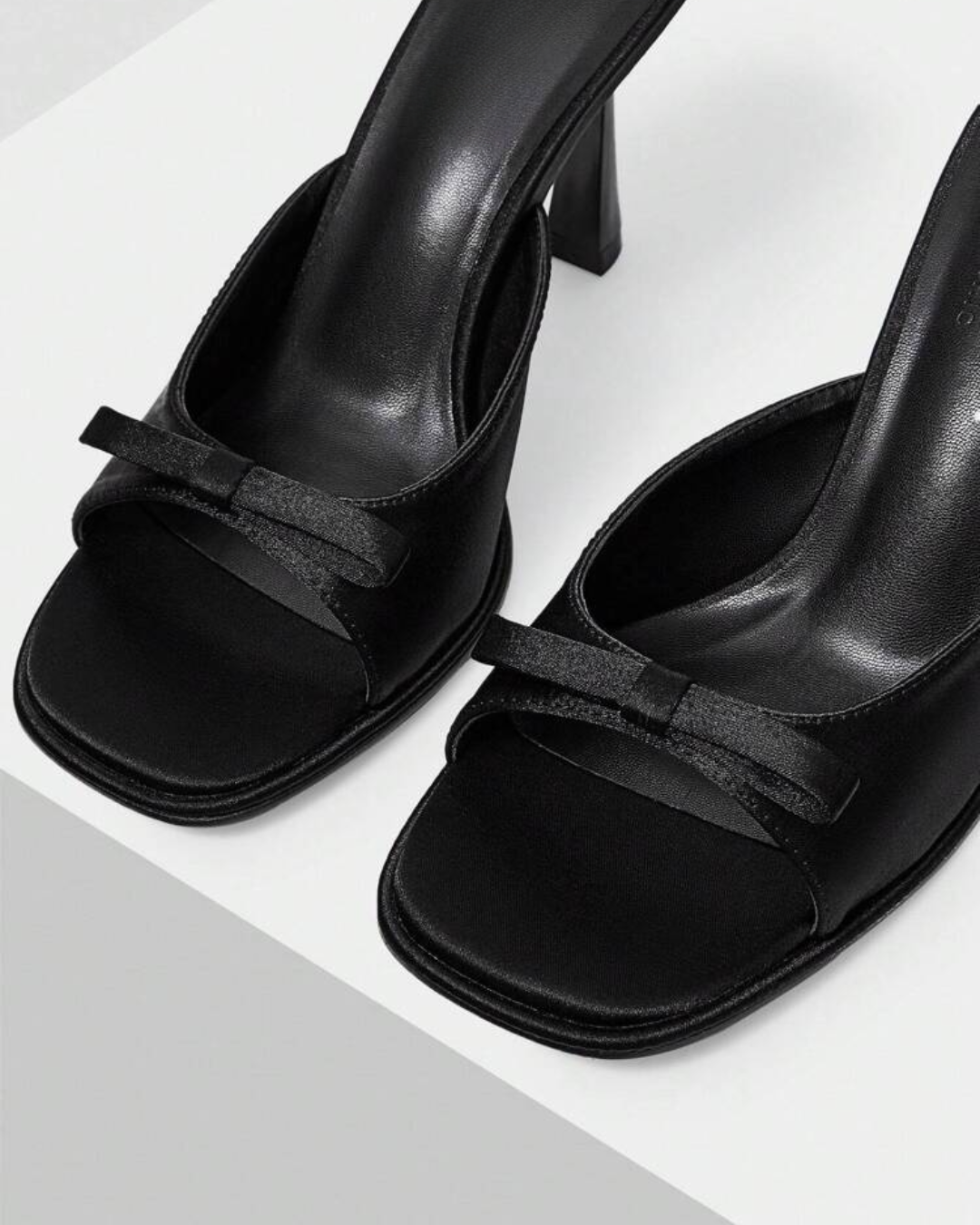 JM Looks heeled mules featuring a small bow detail on the vamp and a sculpted heel
Black