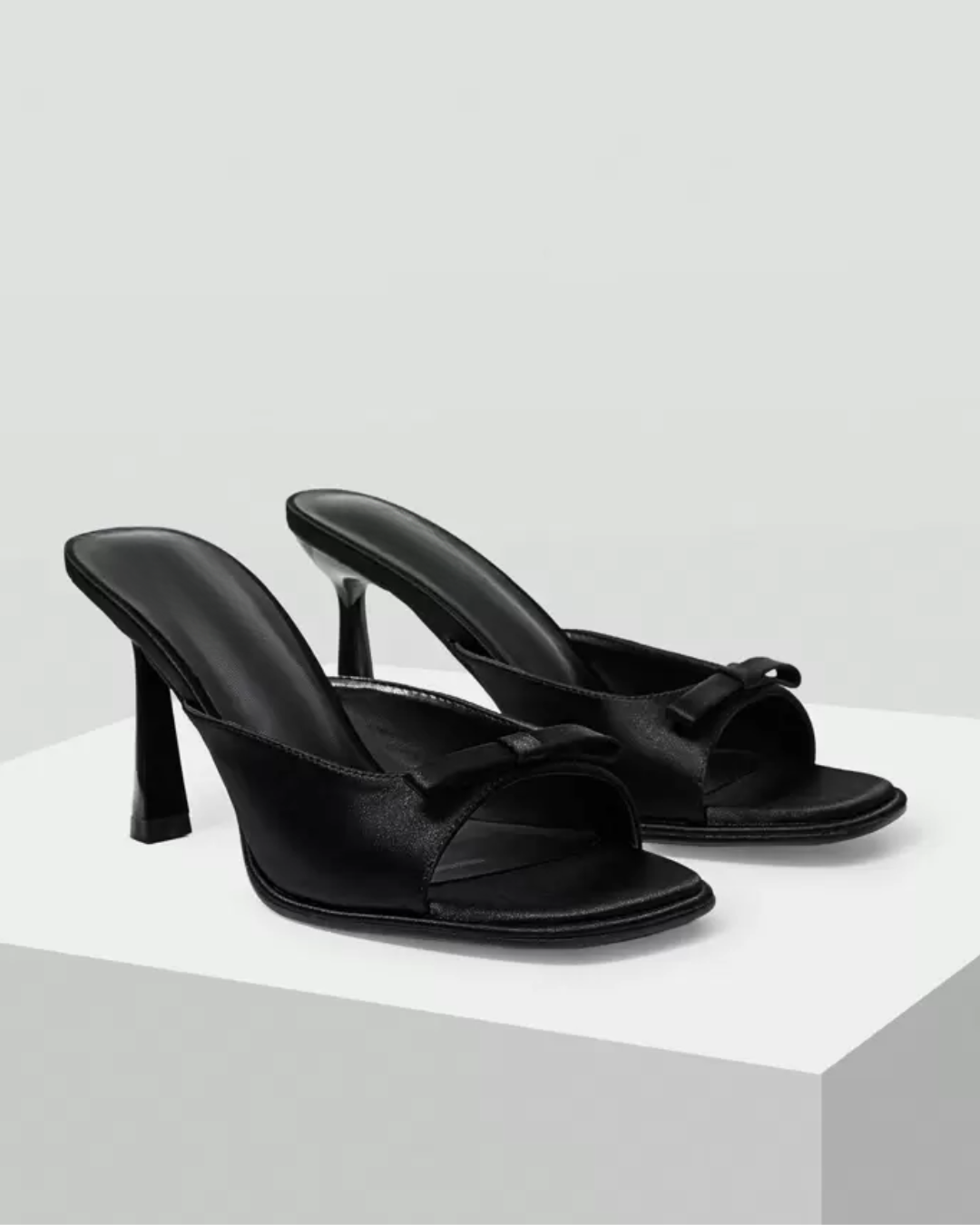 JM Looks heeled mules featuring a small bow detail on the vamp and a sculpted heel
Black