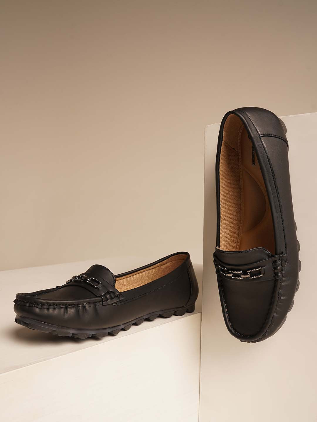 casual loafers with a metal bit embellishment on the vamp and a textured sole
Black