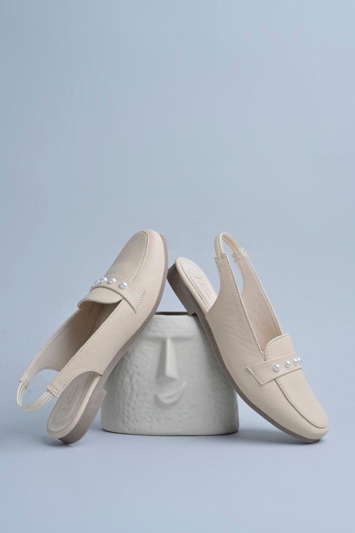 Jm Looks beige slingback loafers adorned with small pearls on the vamp, with a string of pearls in the background
Cream
