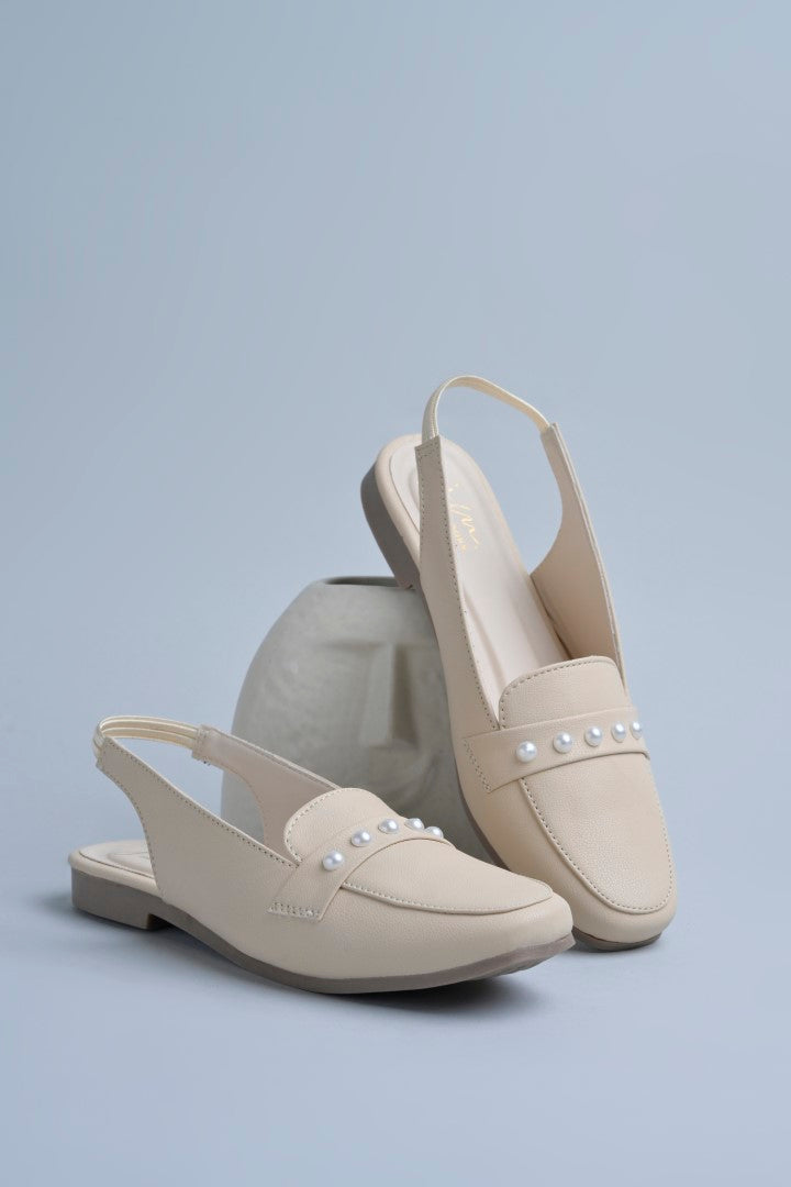 Jm Looks beige slingback loafers adorned with small pearls on the vamp, with a string of pearls in the background
Cream