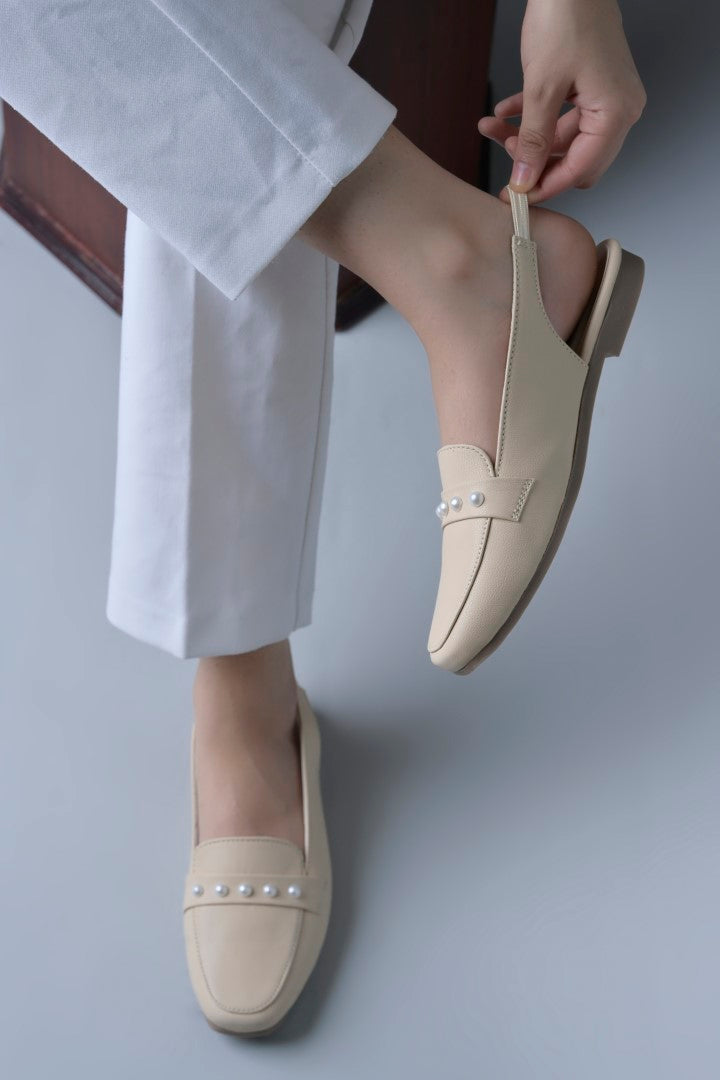 Jm Looks beige slingback loafers adorned with small pearls on the vamp, with a string of pearls in the background
Cream