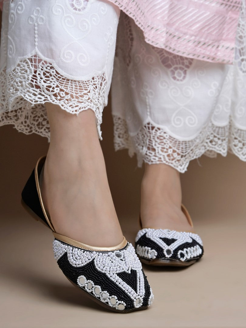 traditional juttis heavily embellished with pearls and beads on the upper
Black