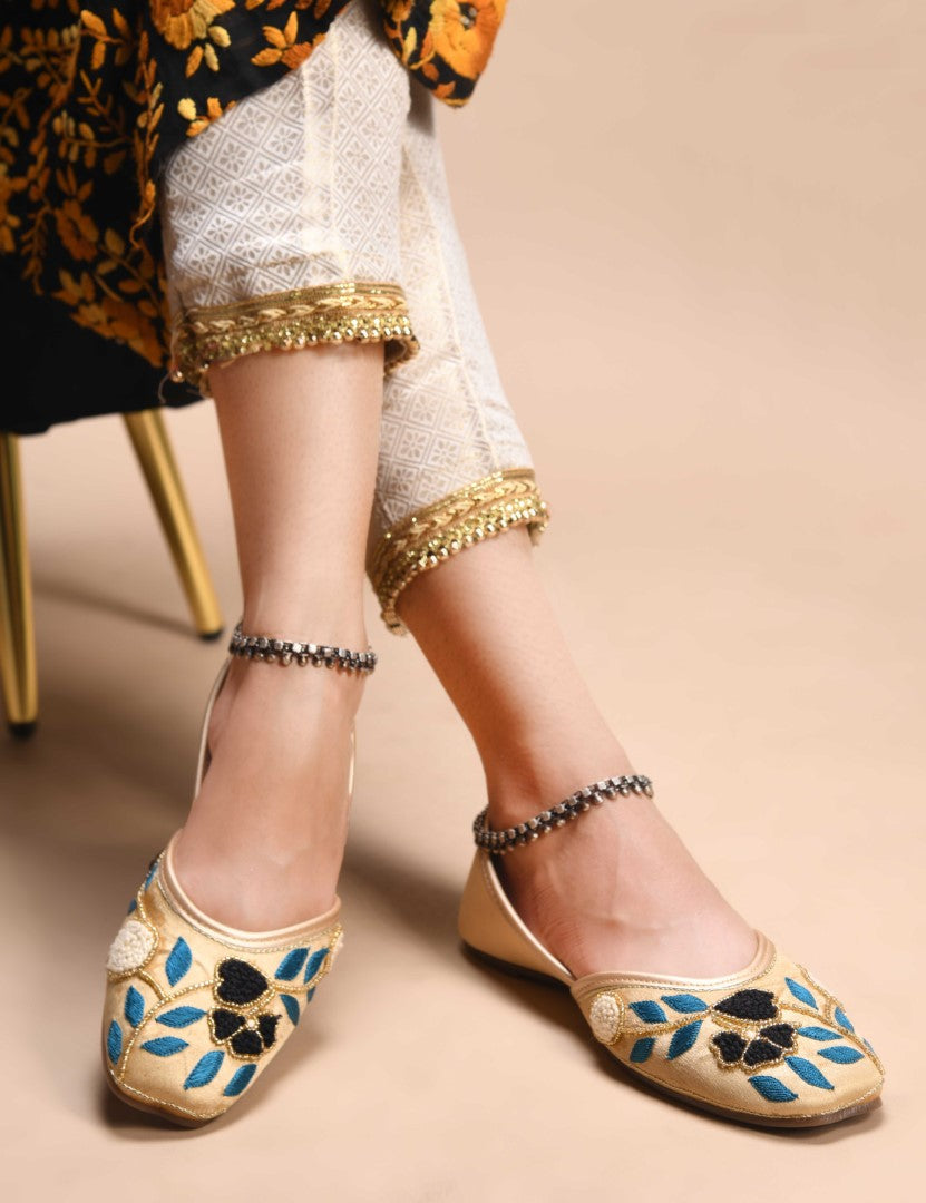 exquisitely embroidered juttis featuring floral and leaf patterns
Golden