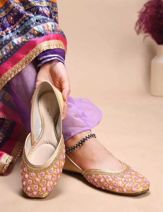 exquisitely embellished juttis featuring a detailed petal design
 Golden