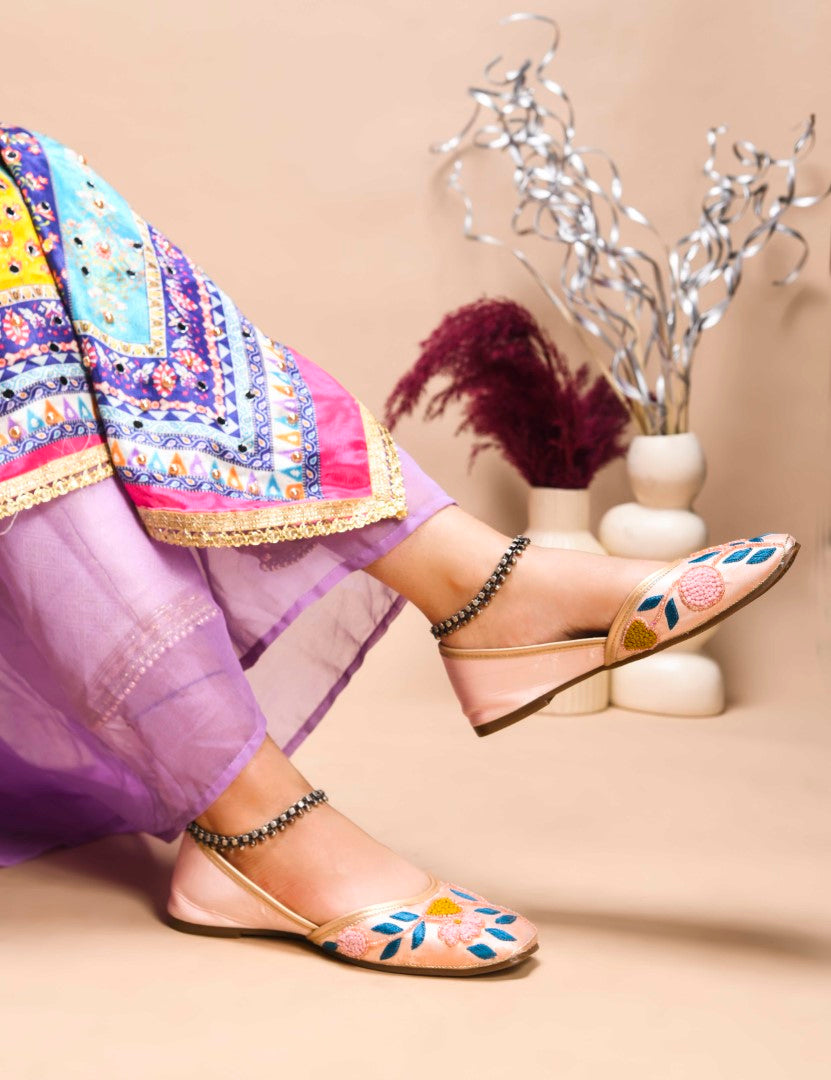 exquisitely embroidered juttis featuring floral and leaf patterns
Peach