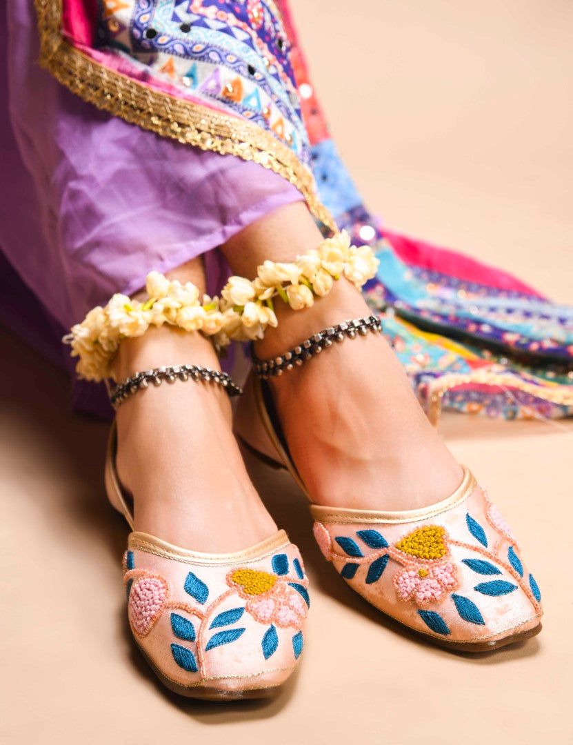 exquisitely embroidered juttis featuring floral and leaf patterns
Peach