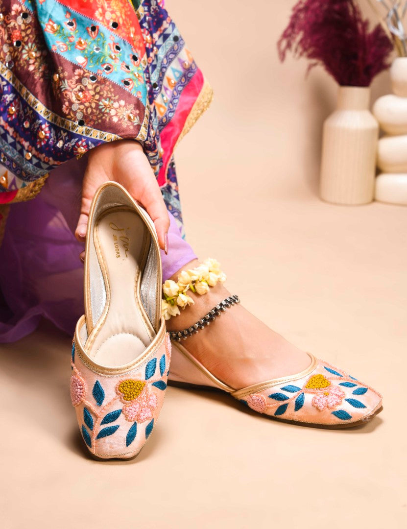 exquisitely embroidered juttis featuring floral and leaf patterns
Peach