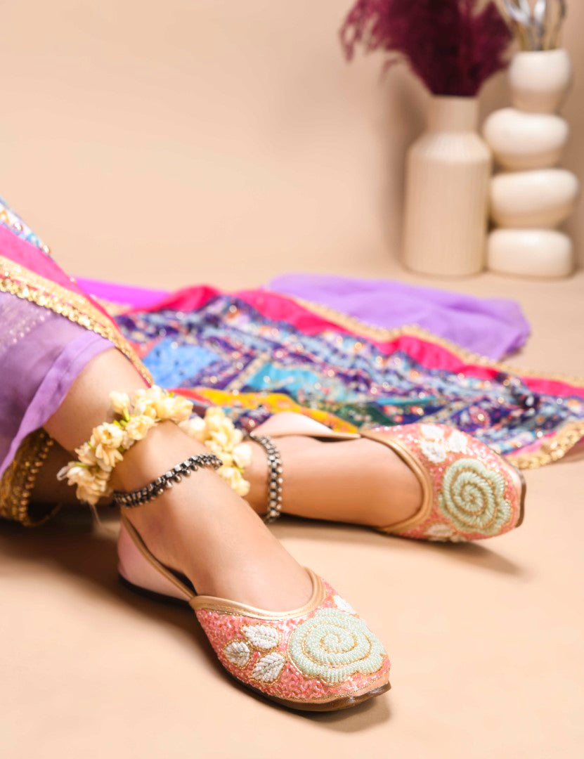 exquisitely beaded juttis featuring a floral design with intricate patterns
Peach