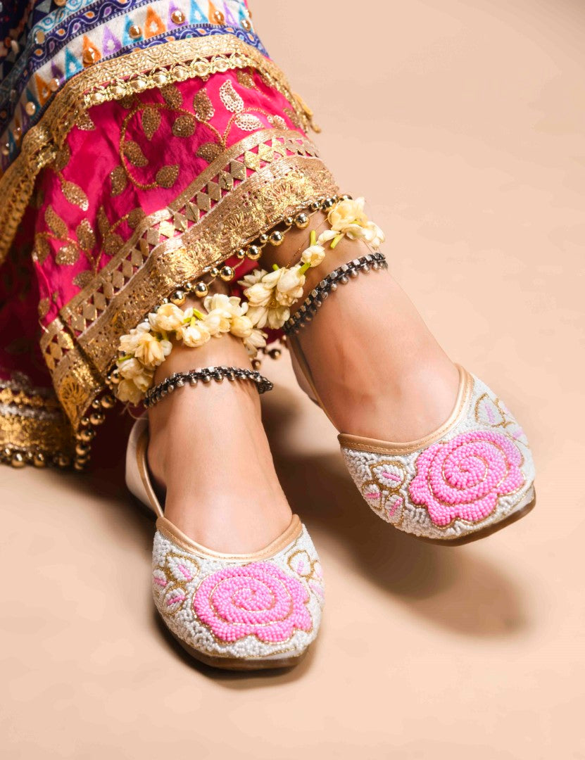 exquisitely beaded juttis featuring a floral design with intricate patterns
White