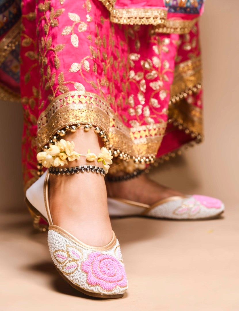 exquisitely beaded juttis featuring a floral design with intricate patterns
White