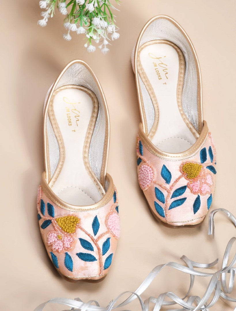 exquisitely embroidered juttis featuring floral and leaf patterns
Peach