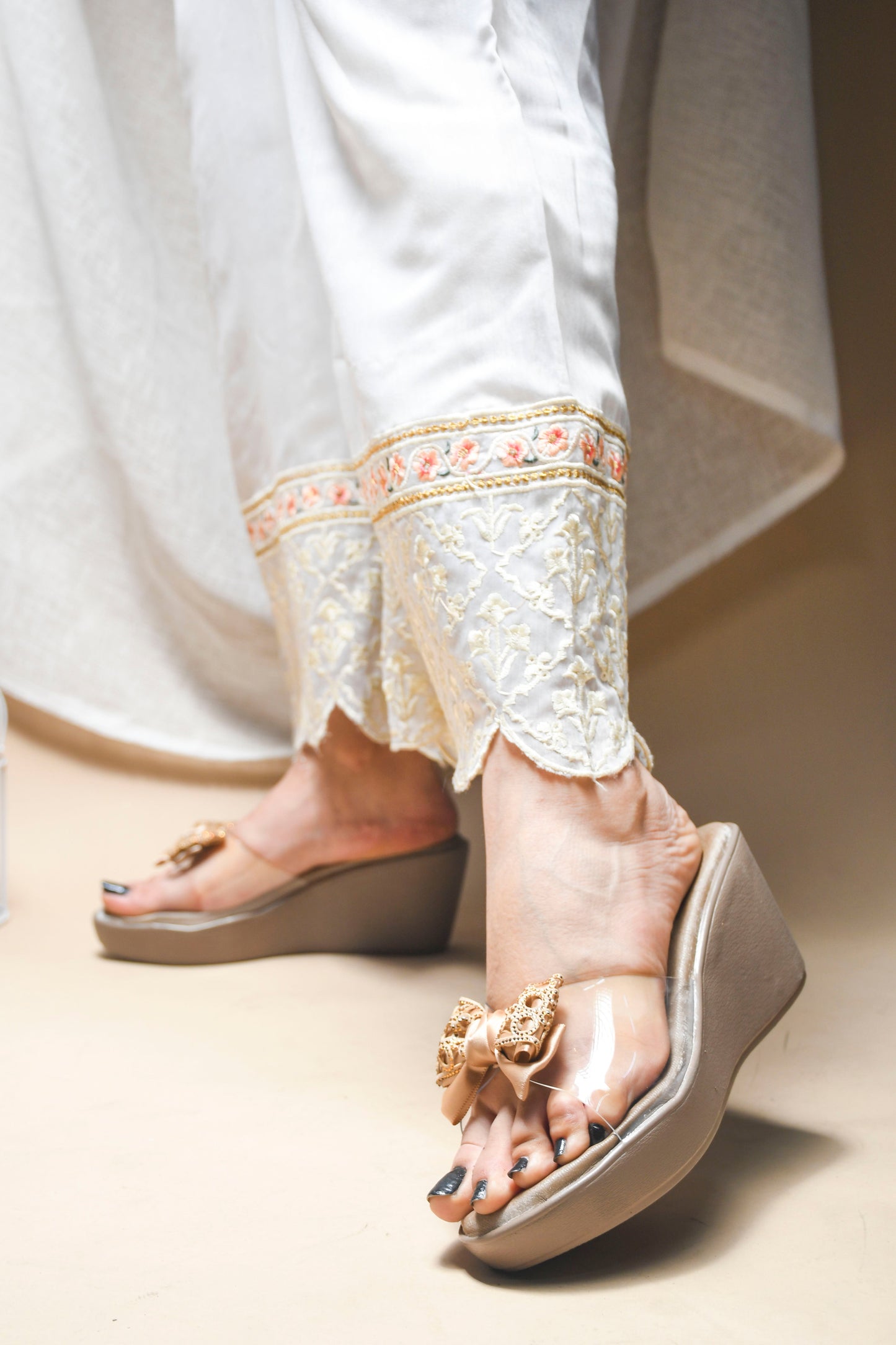Jm Looks embellished bow wedge platform sandals, with one being worn
Beige