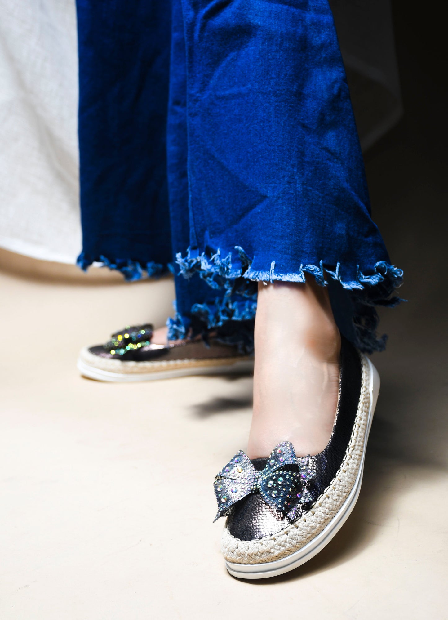 JM Looks espadrille loafers featuring a shimmering toe, a rhinestone-embellished bow, and a woven sole
Grey