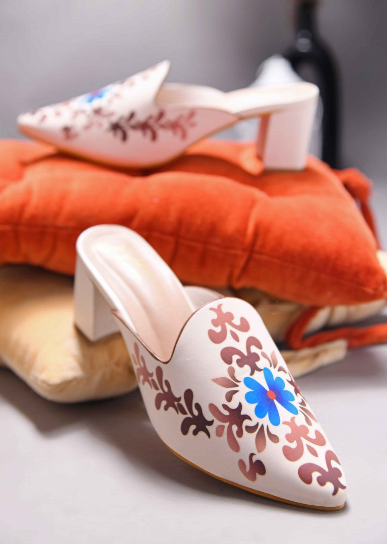 A women's mule shoe featuring a charming floral design and a block heel
Cream