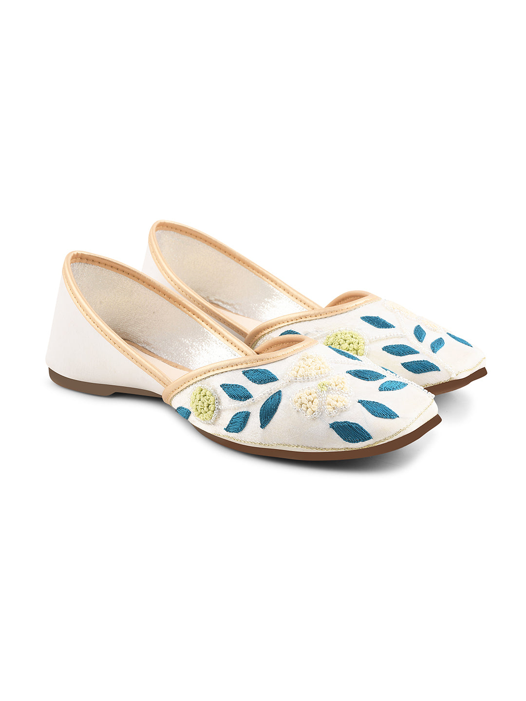 exquisitely embroidered juttis featuring floral and leaf patterns
White