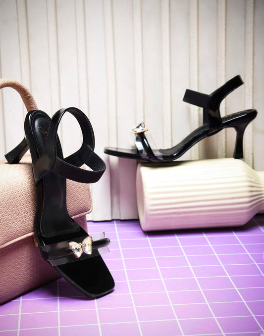heel sandals with a butterfly embellishment on the clear front strap
 Black