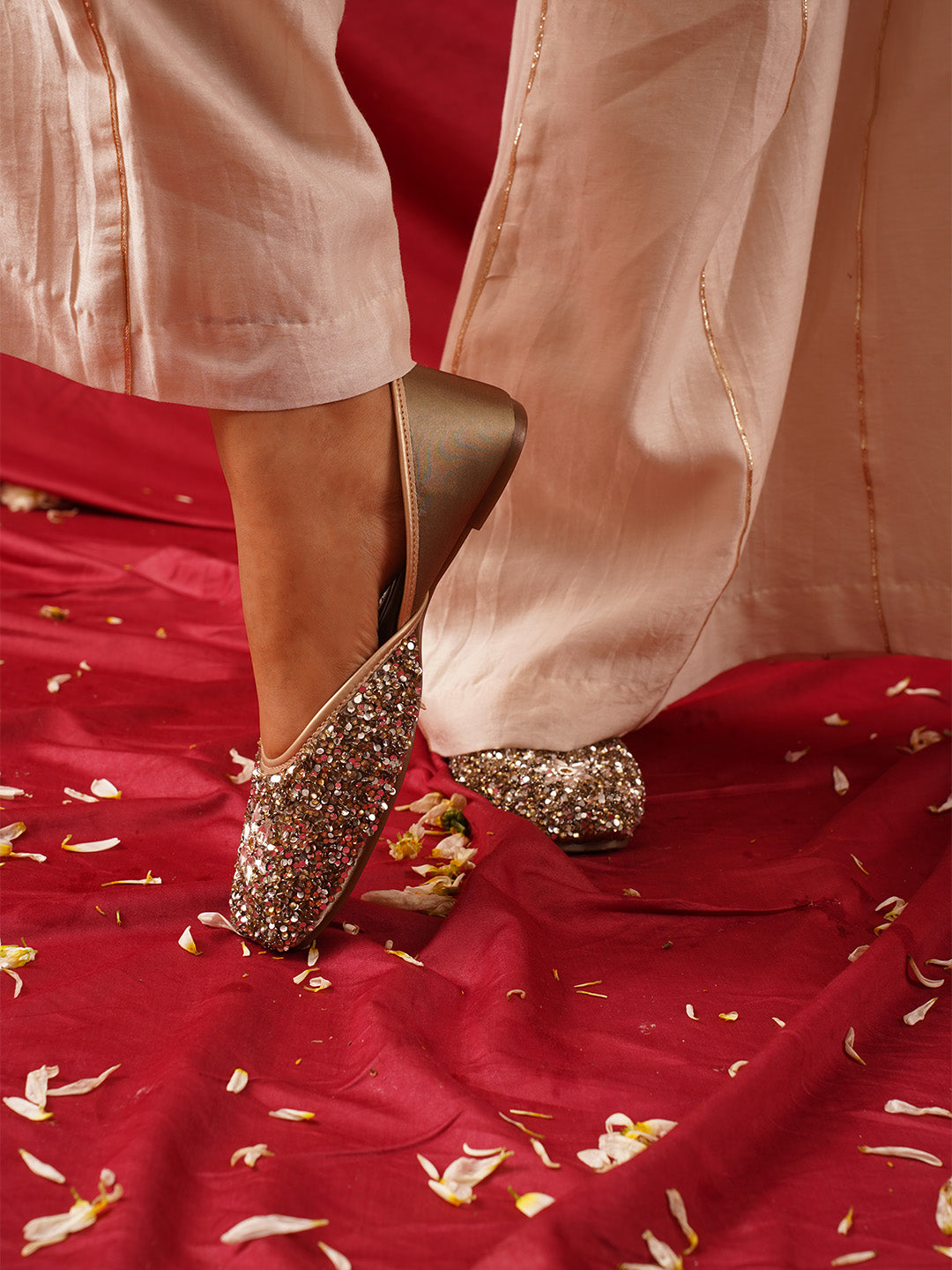 traditional juttis heavily embellished with sequins and a large floral motif at the toe
Green