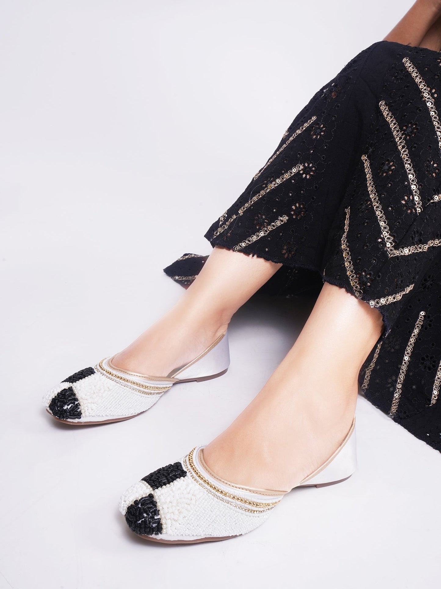 juttis featuring a checkered pattern made from beads
White