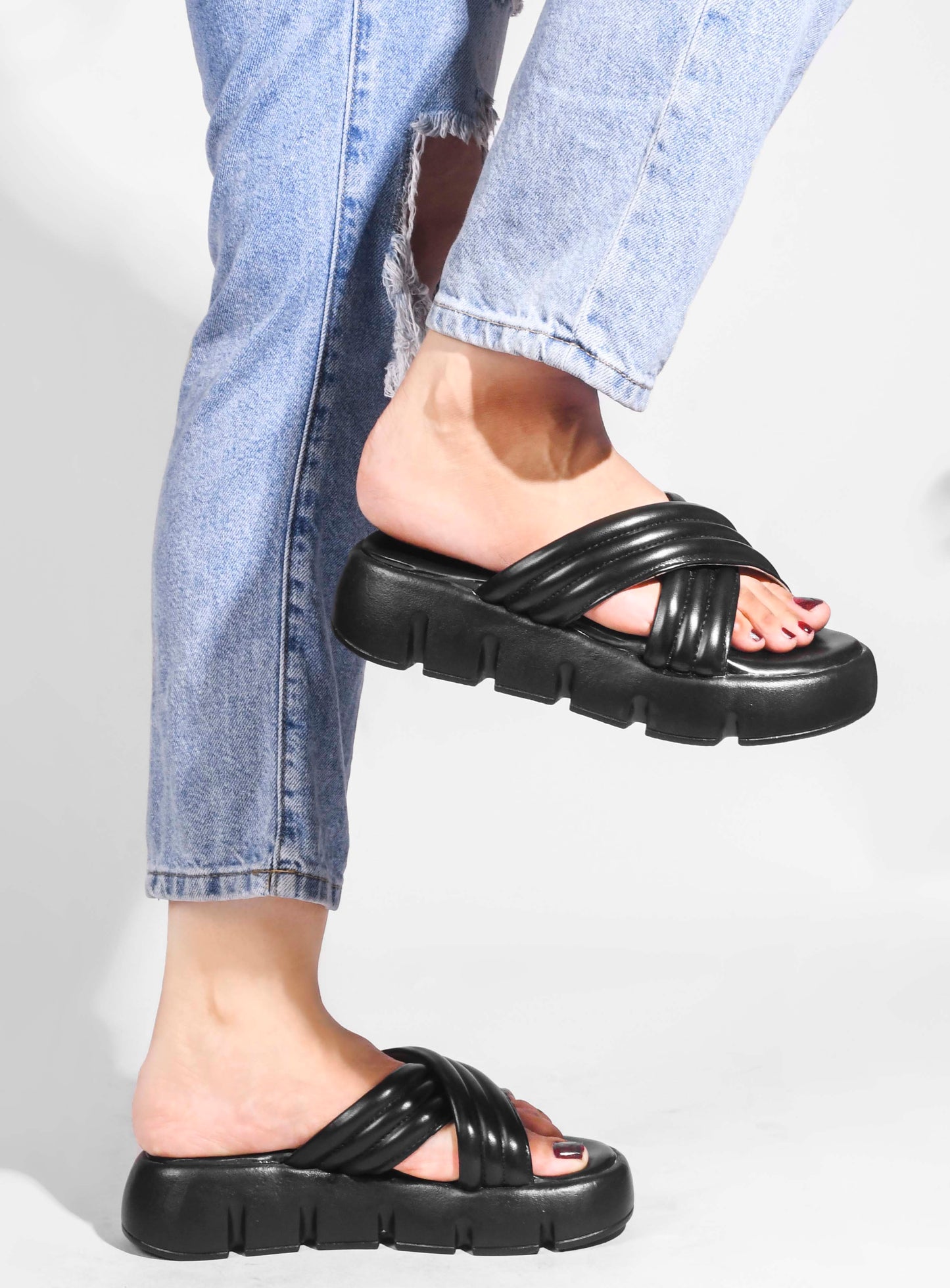 women's platform slides with wide, padded crisscross straps and a chunky lug sole
Black