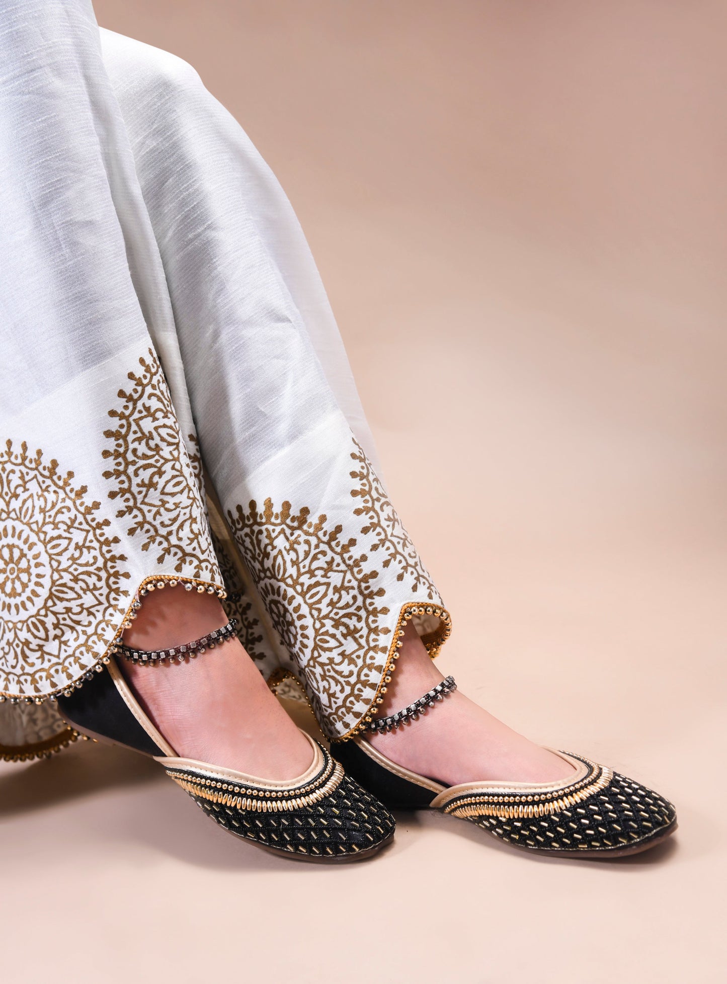 traditional juttis with intricate beaded work in a geometric pattern on the upper
Black