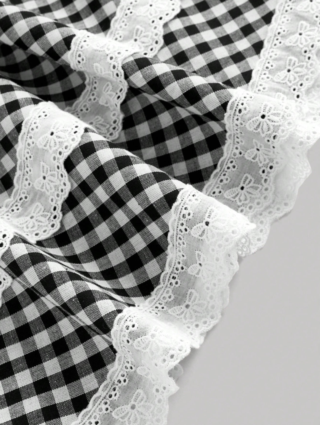 Black gingham lace trim mini dress with sweetheart neckline, bow detail, adjustable straps, and scalloped hem
