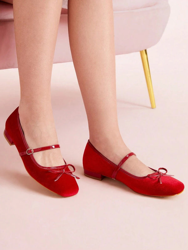 Red velvet Mary Jane ballet flats with bow detail and buckle strap styled