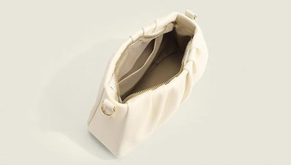 Cream pleated shoulder bag featuring a ruched handle, gold hardware, and pearl chain strap for women.