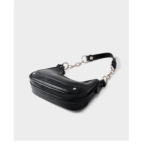 Black chain-strap shoulder bag featuring silver hardware, zip top closure, and trendy structured vegan leather design.