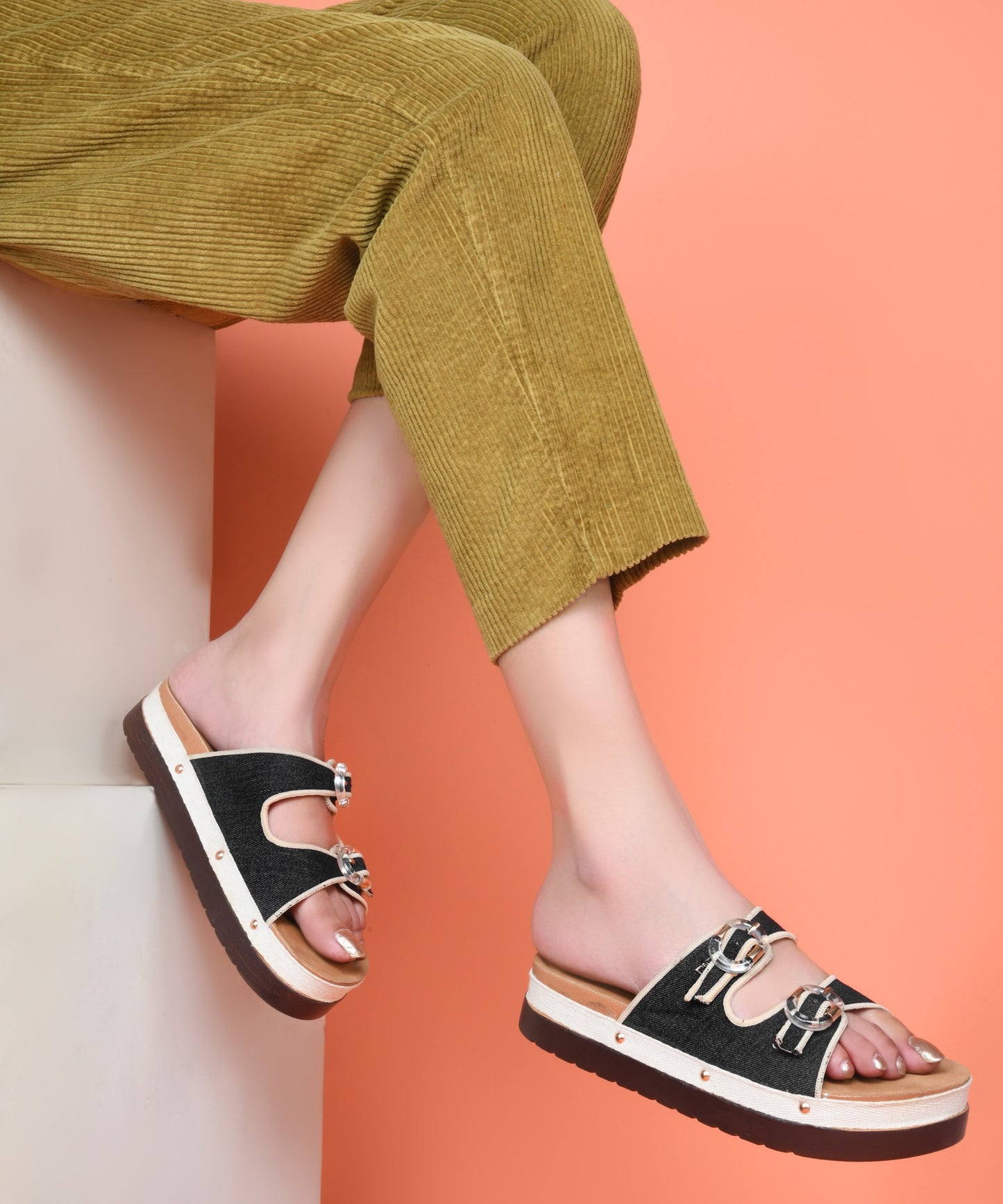 Black denim platform slides for women with dual straps, clear buckles, cushioned tan footbed and chunky sole
