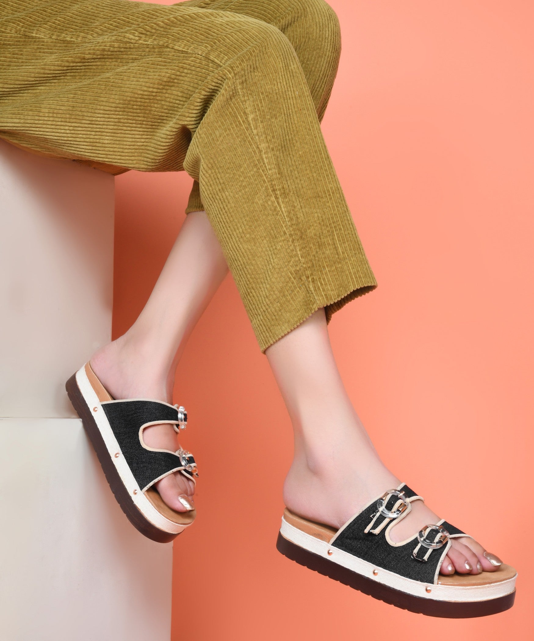 Black denim platform slides for women with dual straps, clear buckles, cushioned tan footbed and chunky sole