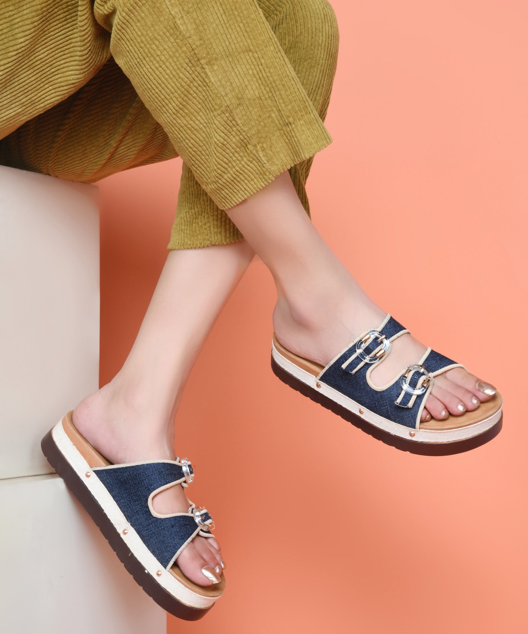 Navy denim platform slides for women with dual straps, clear buckles, cushioned tan footbed and chunky sole