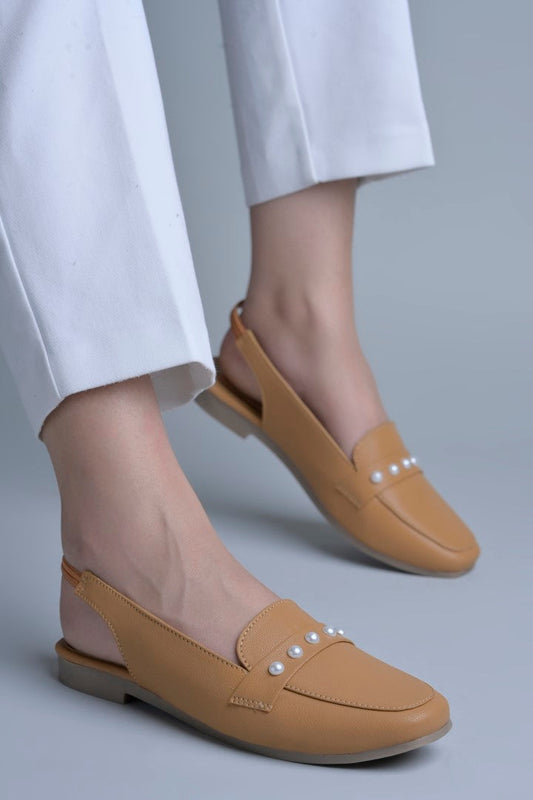 Jm Looks beige slingback loafers adorned with small pearls on the vamp, with a string of pearls in the background
 Beige