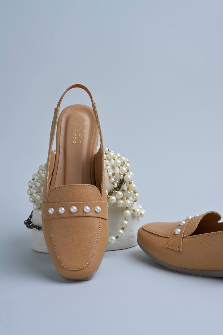 Jm Looks beige slingback loafers adorned with small pearls on the vamp, with a string of pearls in the background
 Beige
