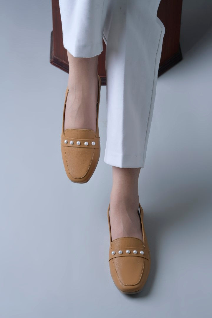 Jm Looks beige slingback loafers adorned with small pearls on the vamp, with a string of pearls in the background
 Beige