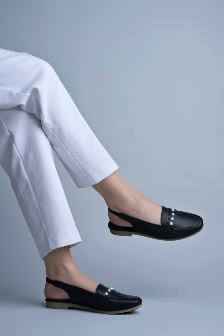 Jm Looks beige slingback loafers adorned with small pearls on the vamp, with a string of pearls in the background
 Black