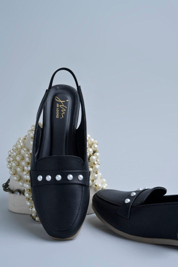 Jm Looks beige slingback loafers adorned with small pearls on the vamp, with a string of pearls in the background
 Black