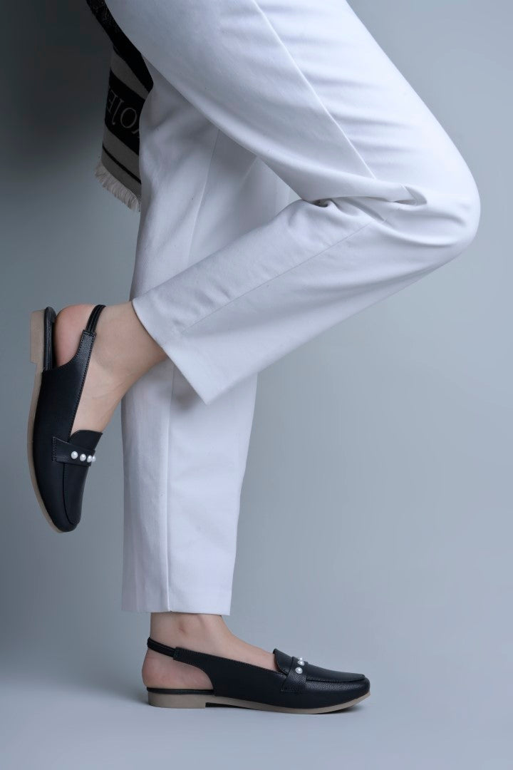 Jm Looks beige slingback loafers adorned with small pearls on the vamp, with a string of pearls in the background
 Black