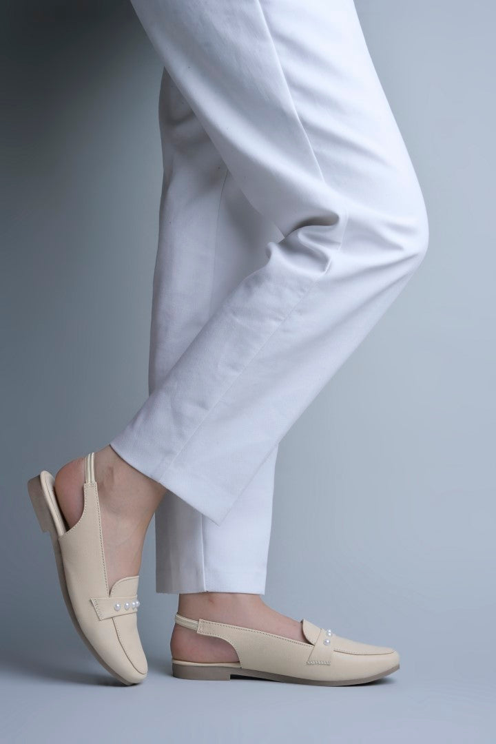 Jm Looks beige slingback loafers adorned with small pearls on the vamp, with a string of pearls in the background
 Cream