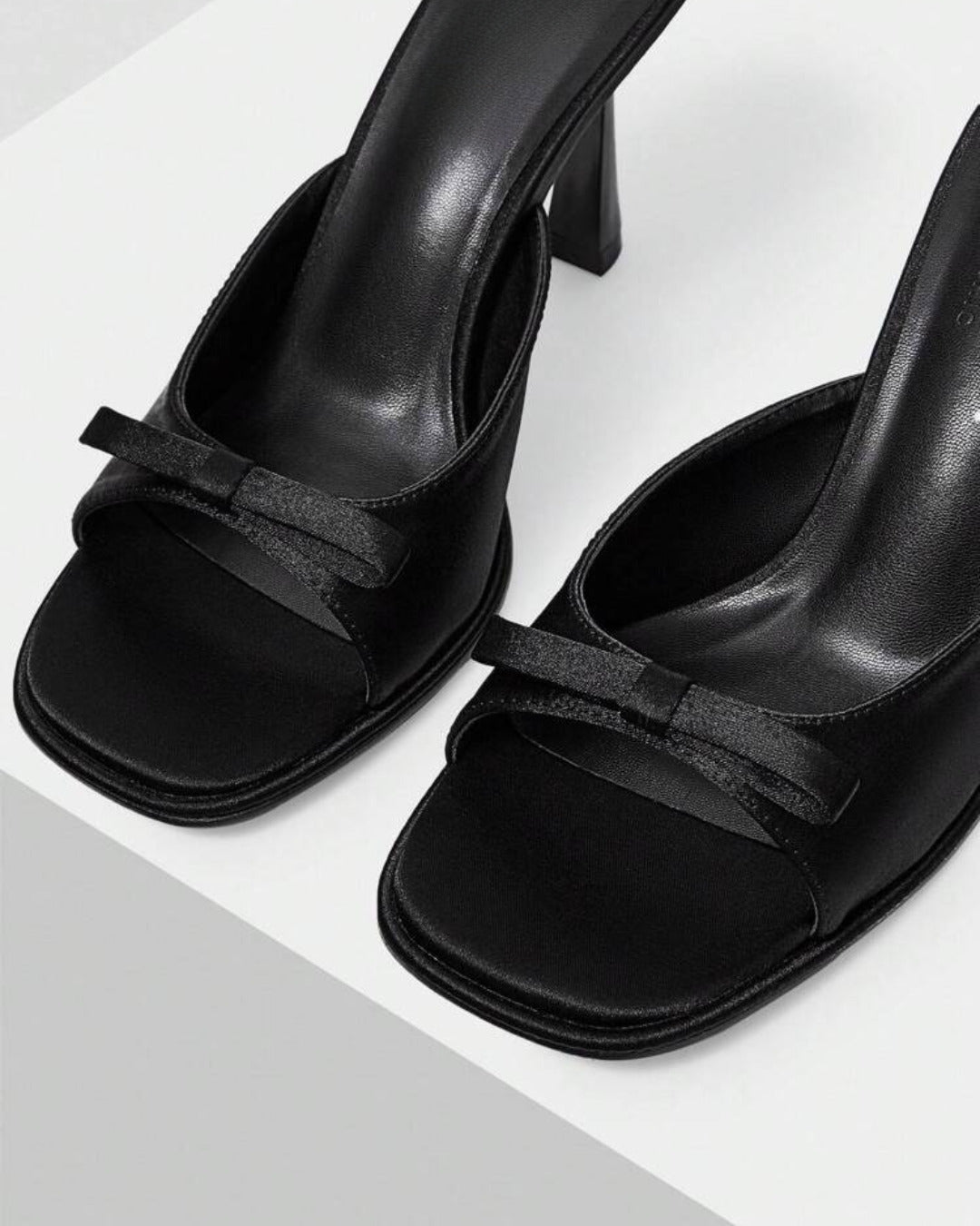JM Looks heeled mules featuring a small bow detail on the vamp and a sculpted heel
 Black