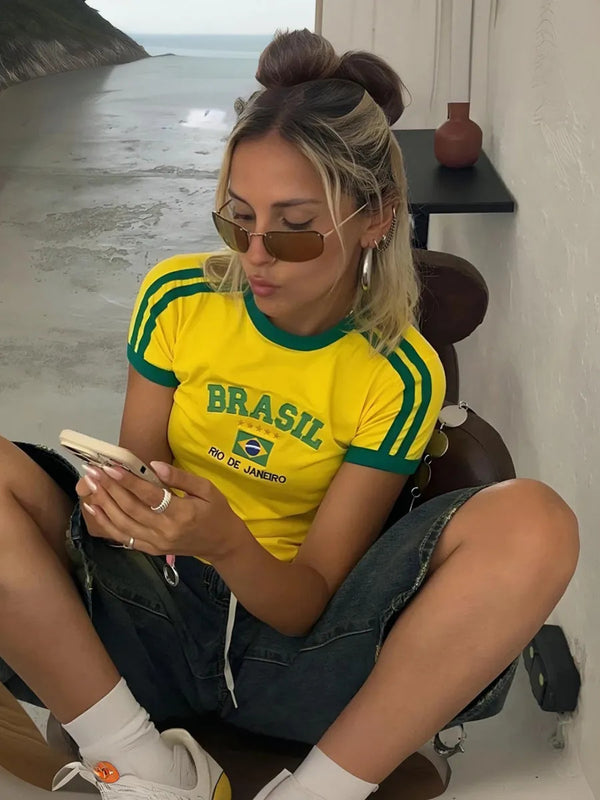 Yellow Brasil printed crop top with green striped sleeves, round neckline and Rio de Janeiro graphic