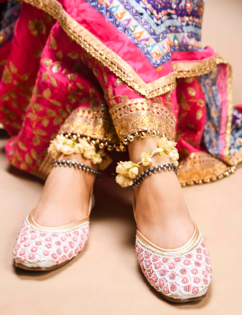 exquisitely embellished juttis featuring a detailed petal design
 White