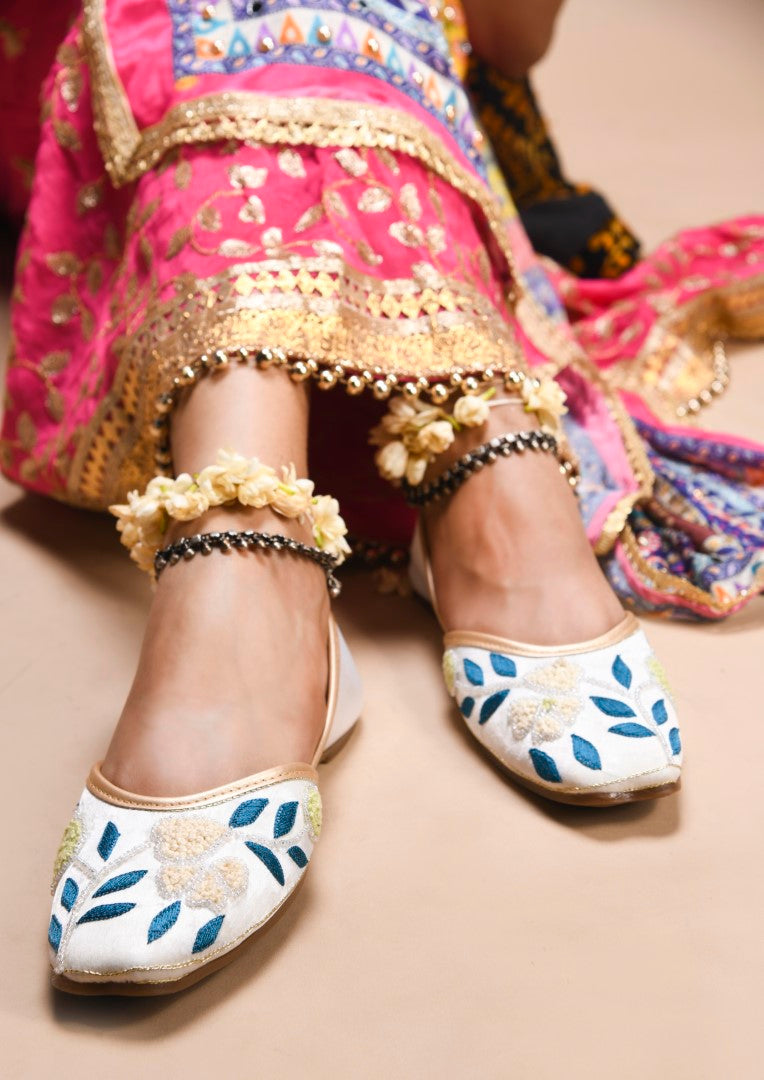 exquisitely embroidered juttis featuring floral and leaf patterns
 White