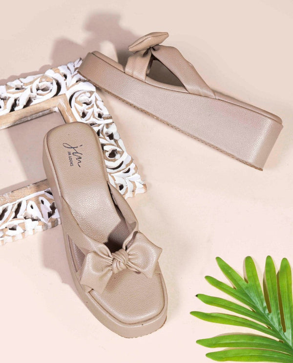 Tan platform wedge sandals featuring twisted bow straps and cushioned footbed for elegant comfortable everyday styling