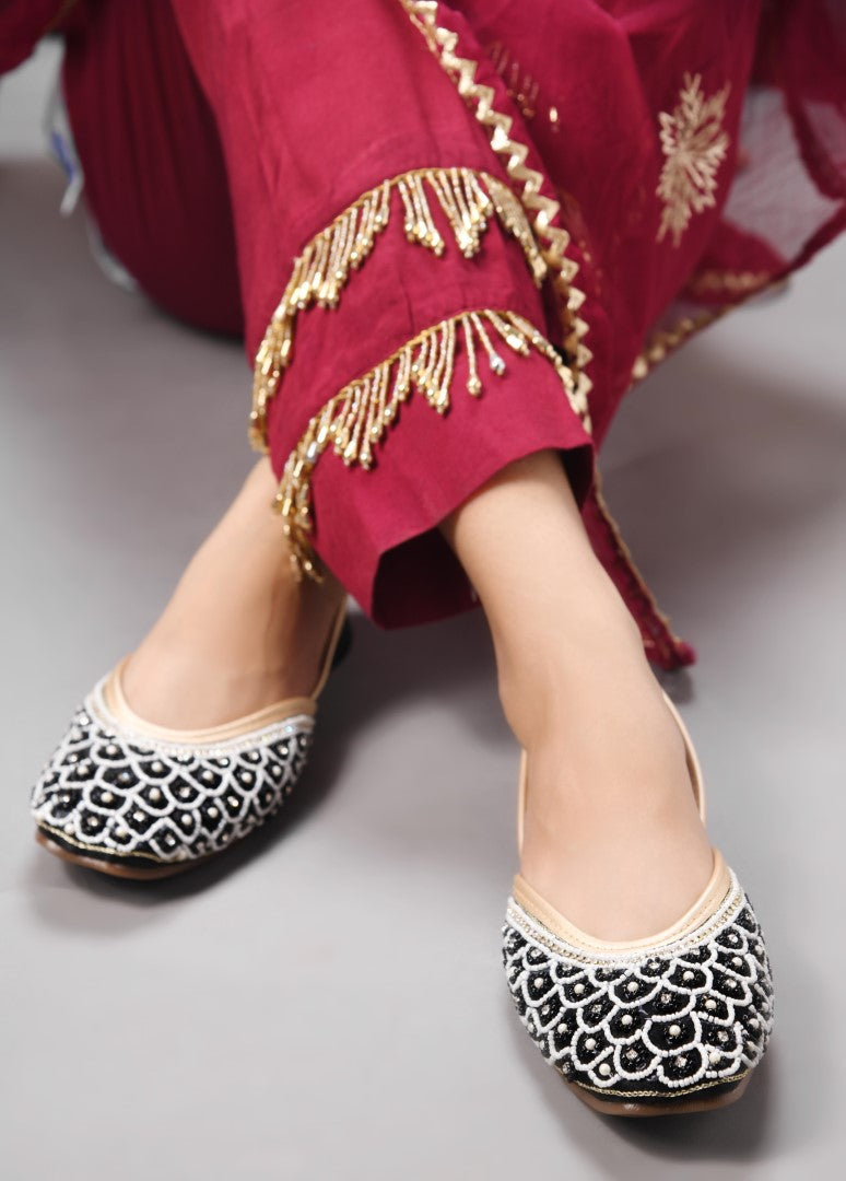 exquisitely embellished juttis featuring a detailed petal design
 Black