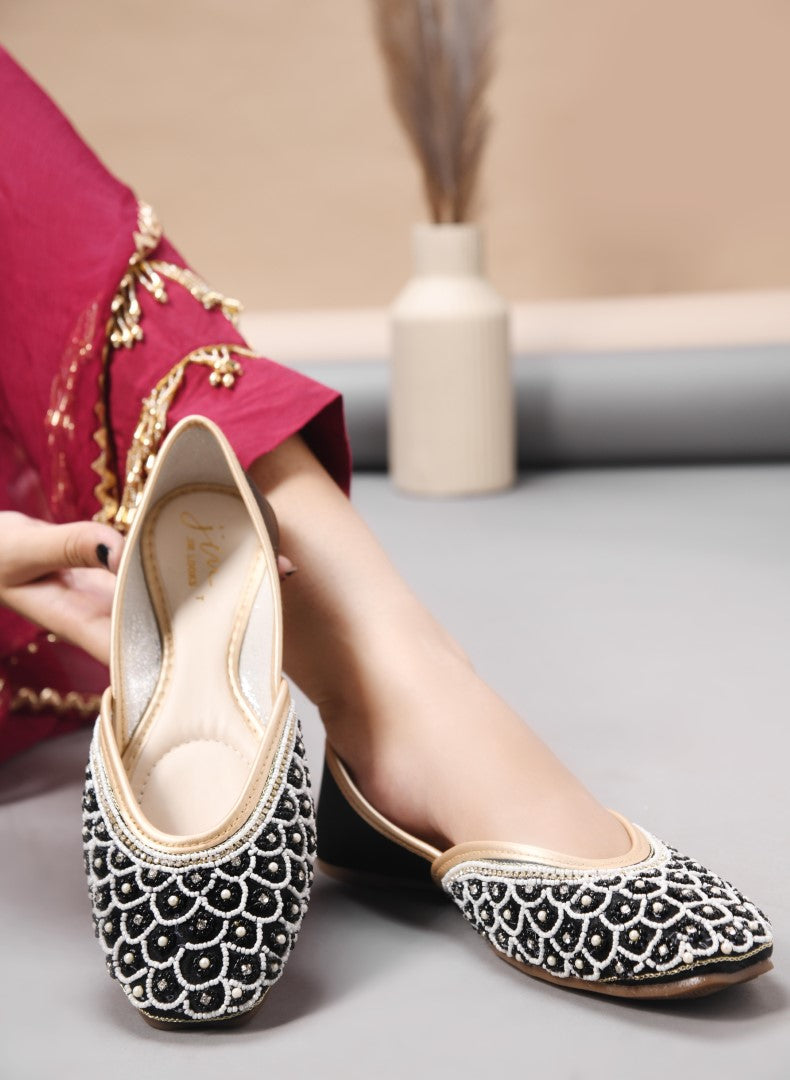exquisitely embellished juttis featuring a detailed petal design
 Black