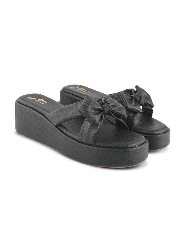 Black platform wedge sandals featuring twisted bow straps and cushioned footbed for elegant comfortable everyday styling