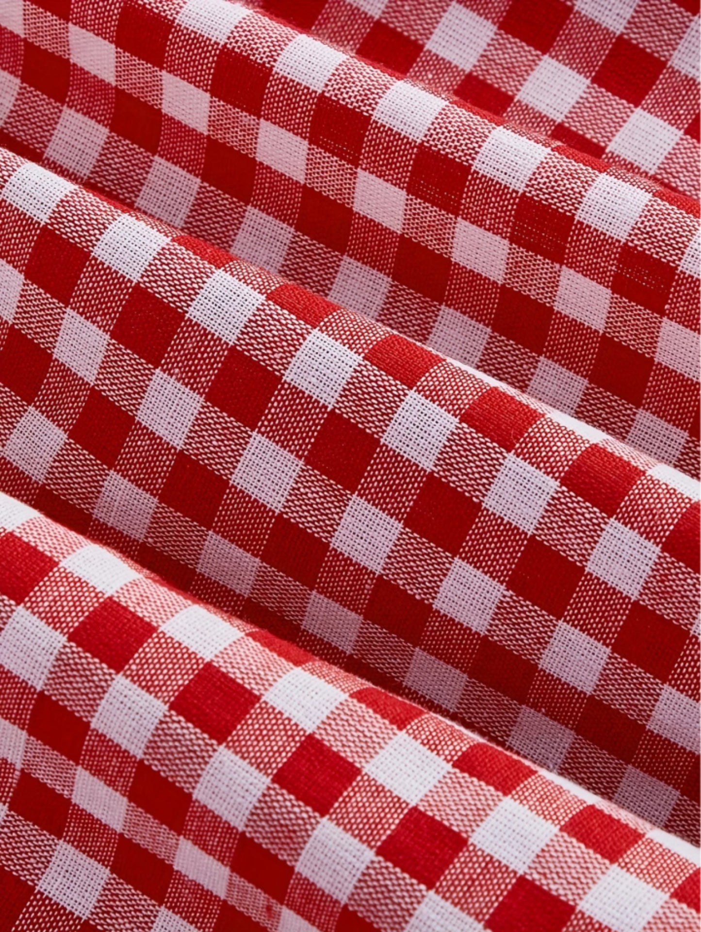 Red gingham sleeveless mini dress with bow detail, sweetheart neckline, wide straps, and flared A-line skirt