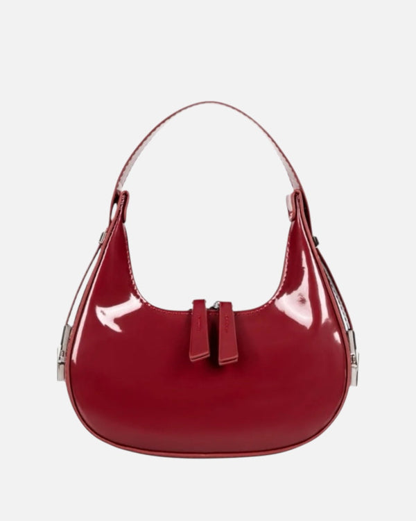 Burgundy half moon handbag for women in glossy patent finish with curved crescent shape and dual zip pulls.