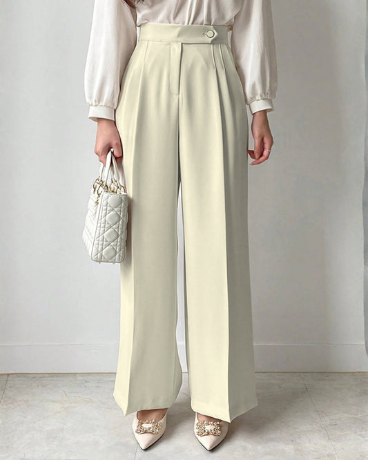 Cream high-waisted wide-leg pleated trousers for women styled with white blouse and embellished pointed satin heels